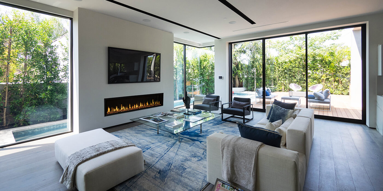 A modern living room with a linear fireplace installed below a flatscreen TV.